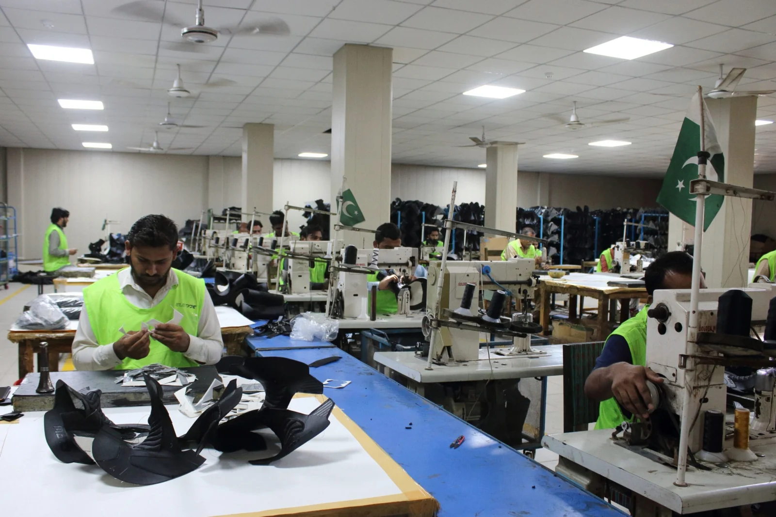 Motorcycle gear production: worker assembling black boot uppers