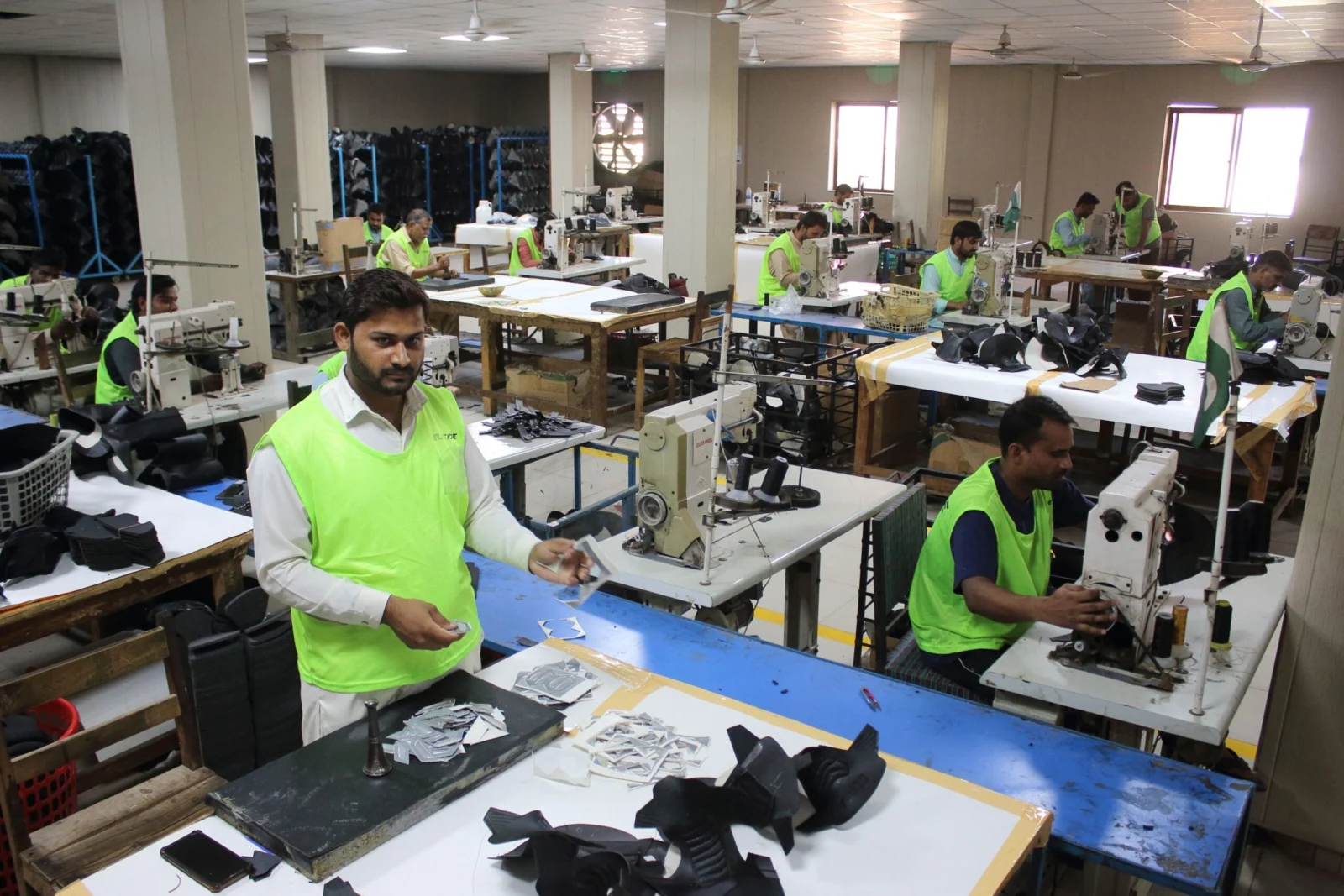 Motorcycle gear manufacturing: workers preparing boot components at ELEONE’s Sialkot facility