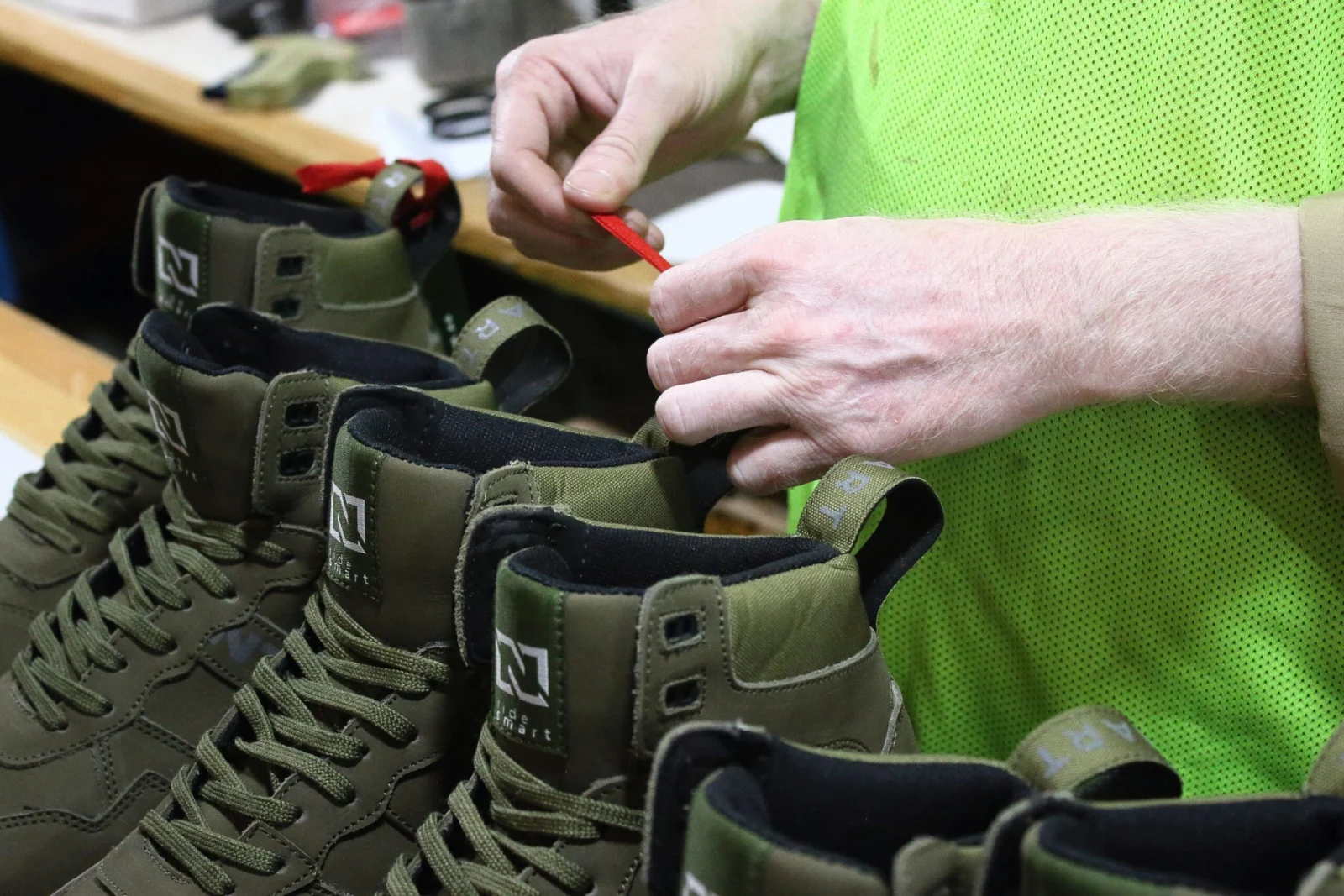 Worker checking laces and finishing details on motorcycle boots