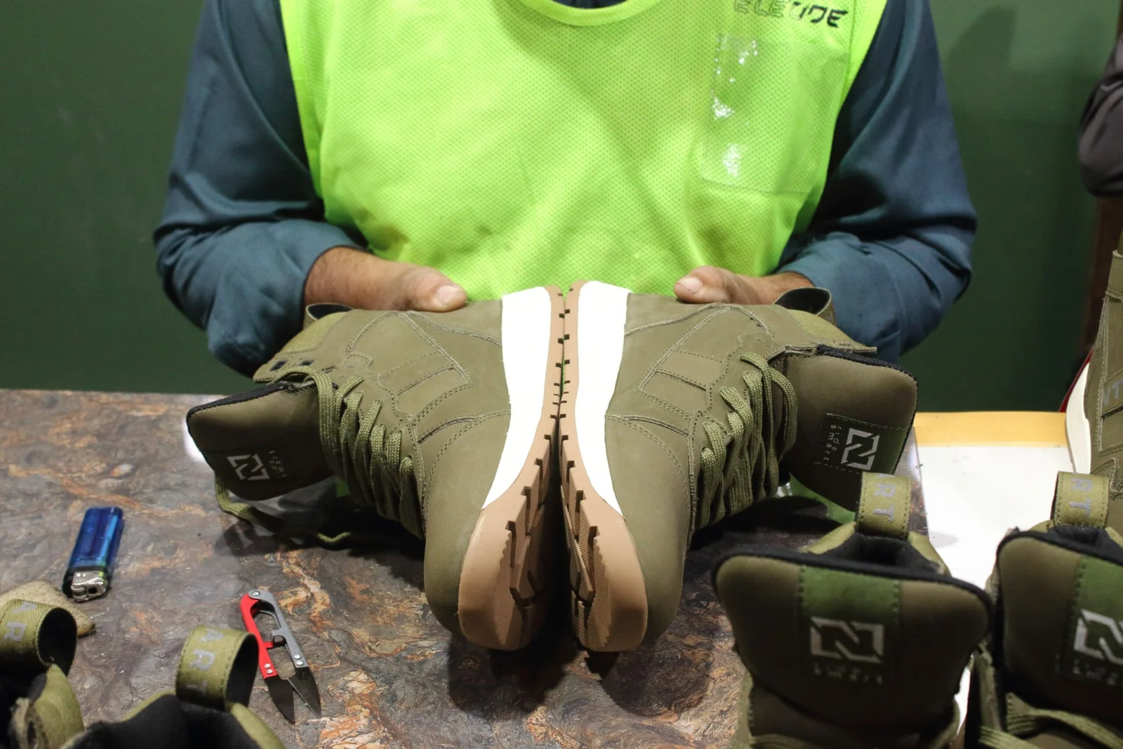 Worker comparing the soles of two motorcycle boots