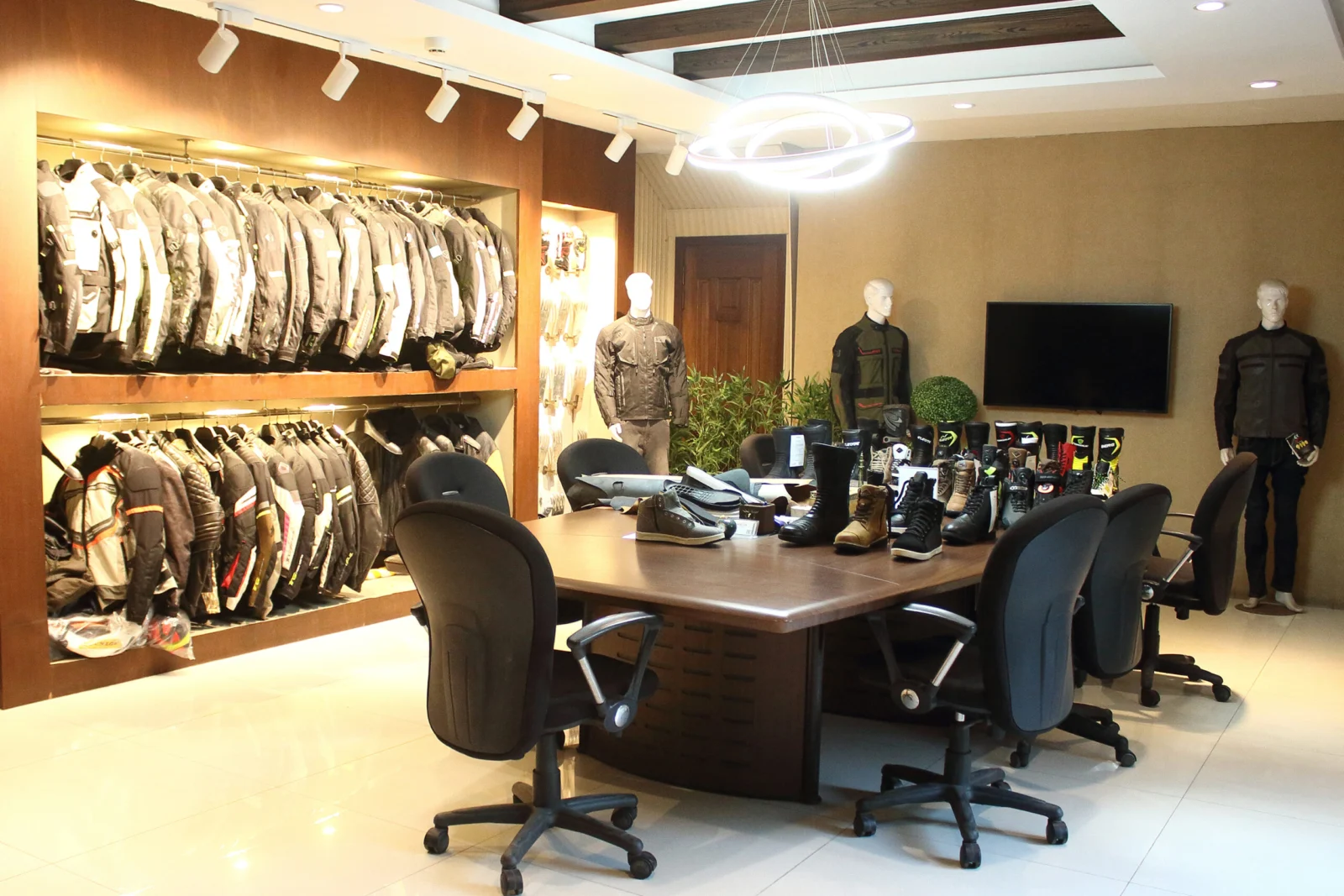 ELEONE showroom displaying motorcycle jackets and footwear samples — motorcycle gear catalogue